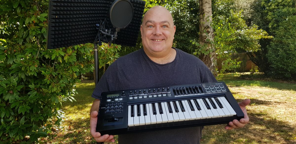 Shane Searls outside his home in regional Victoria with his keyboard.