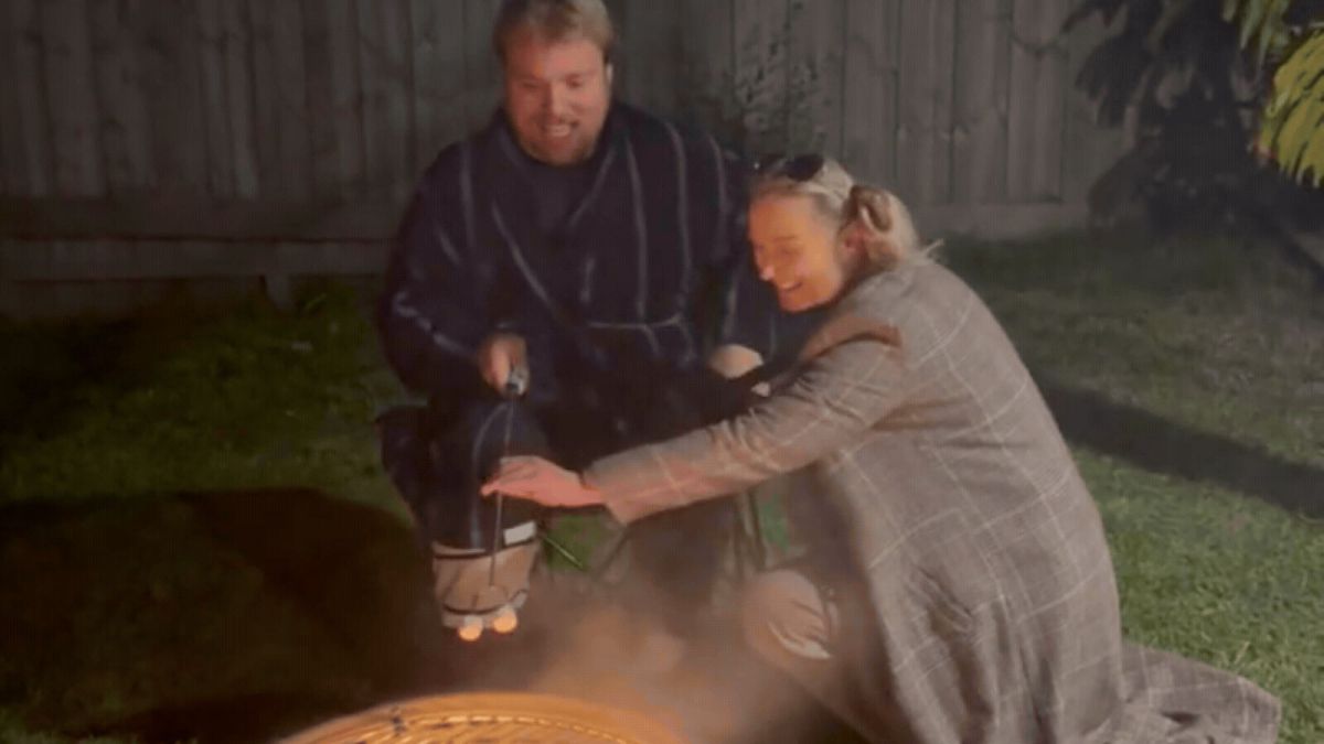 Lewis and Sylvia toasting marshmallows on a fire pit